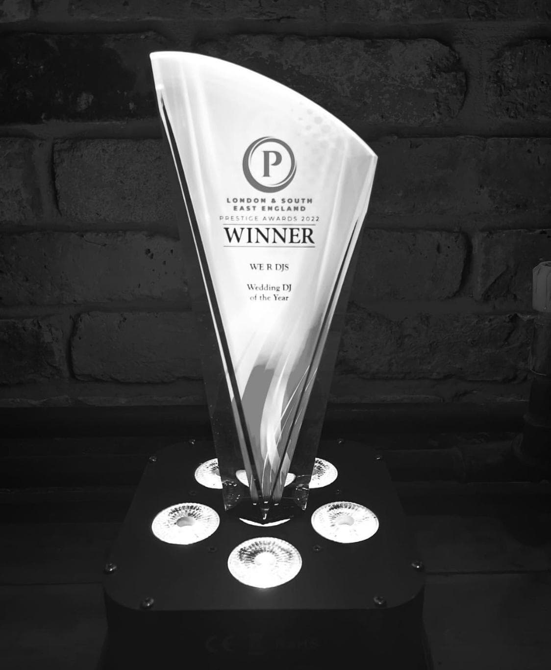 A trophy with a sleek, modern design, labeled 'WINNER' and indicating 'WE R DJS' for 'Wedding DJ of the Year' at the London & South East England Prestige Awards 2022.
